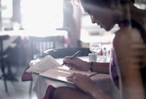 woman sitting at a table writing